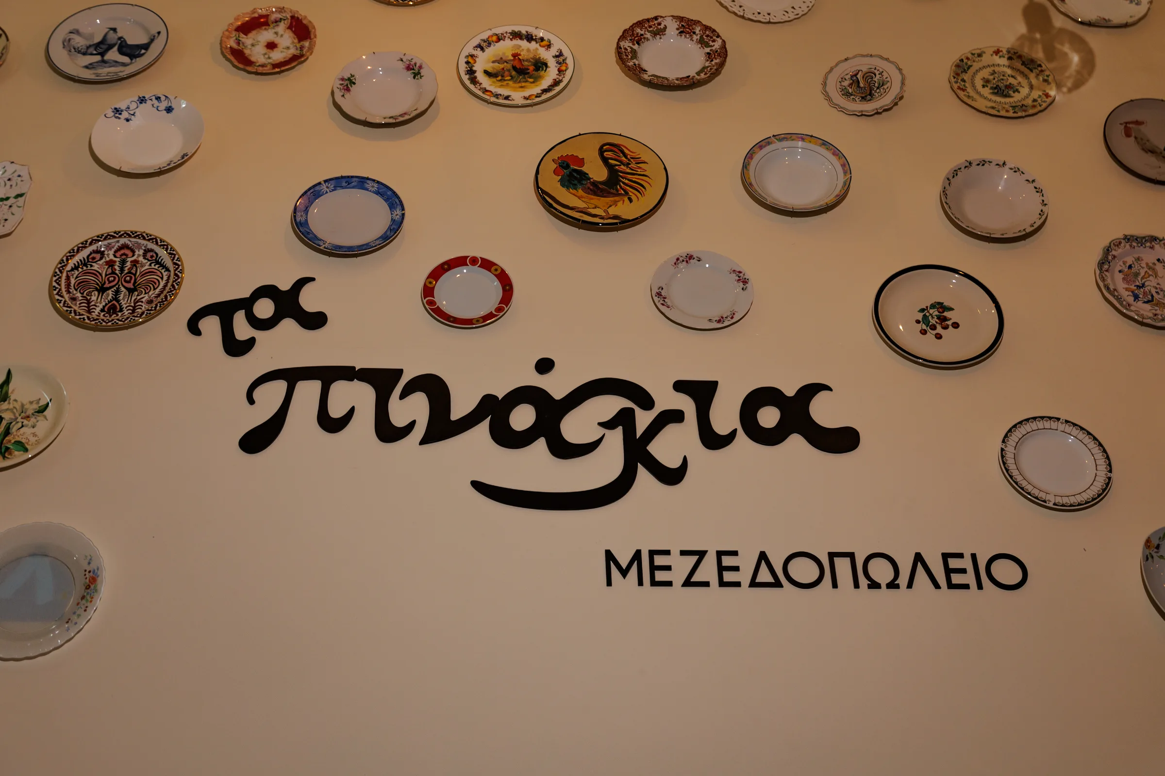Ta Pinakia logo wall with decorative ceramic plates