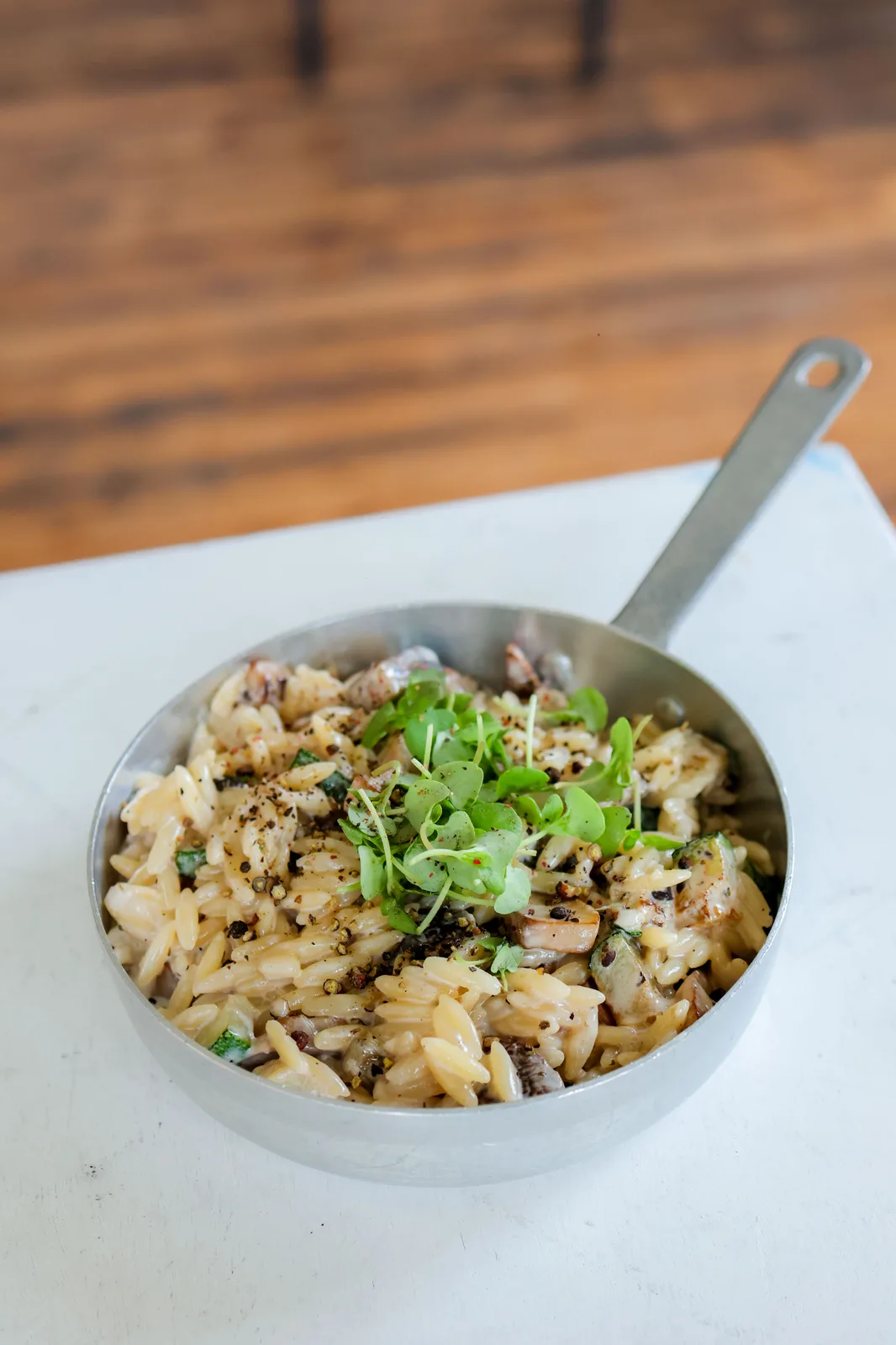 Orzo cooked in a pan with fresh herbs