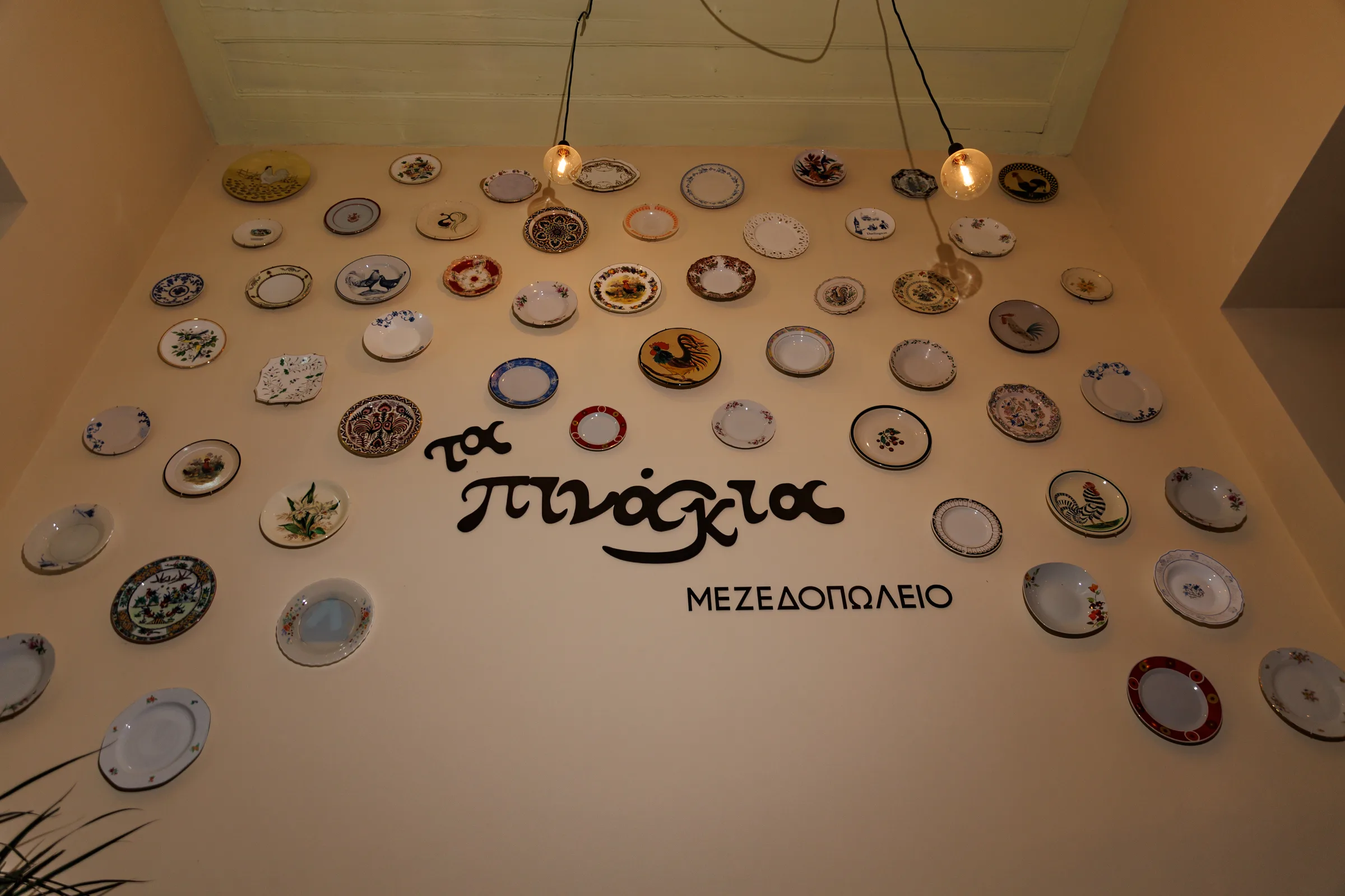 Ta Pinakia logo wall with decorative ceramic plates